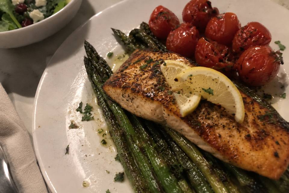 A dim, blurry phone photo of the same salmon dish